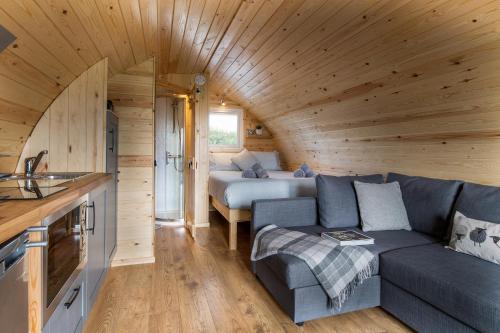 a living room with a couch and a bed in a cabin at Waenfechan Glamping with Hot Tubs in Colwyn Bay