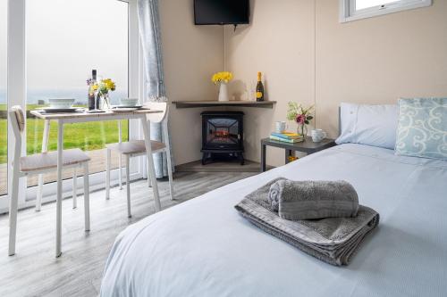 a bedroom with a bed and a table and a fireplace at Waenfechan Glamping in Colwyn Bay