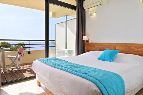 a bedroom with a large bed and a balcony at Résidence Les Calanques in Ajaccio