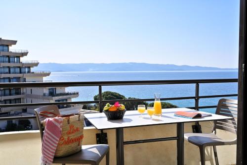 a table with two glasses of orange juice on a balcony at Résidence Les Calanques in Ajaccio