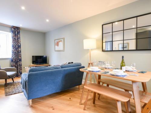 a living room with a blue couch and a table at Conybeare Cottage in Lyme Regis
