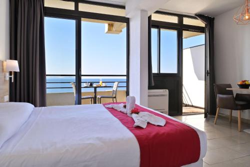 a bedroom with a bed and a view of the ocean at Résidence Les Calanques in Ajaccio