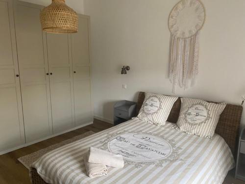 a bedroom with a bed with two faces on the pillows at HOME ET HOLIDAY Le Petit Verdot in Viviers