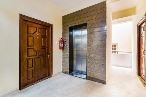 a hallway with a wooden door and a brick wall at OYO Kartikeya Park View Residency in Chittoor