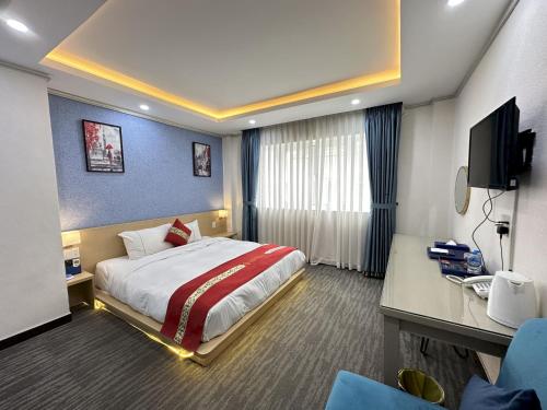 Habitación de hotel con cama y escritorio en Capital O 1177 Saigon Sweet Hotel en Ho Chi Minh