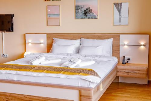 a bedroom with a large white bed with two towels at AirStar in Surčin