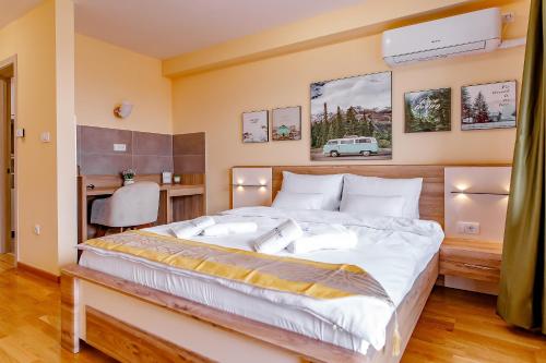 a bedroom with a large bed with a desk and a chair at Hotel AirStar in Surčin