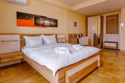 a large white bed in a room with wooden floors at AirStar in Surčin