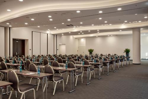 an empty room with tables and chairs in a hall at HYPERION Hotel Hamburg in Hamburg