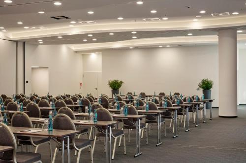 a room full of tables and chairs in a hall at HYPERION Hotel Hamburg in Hamburg
