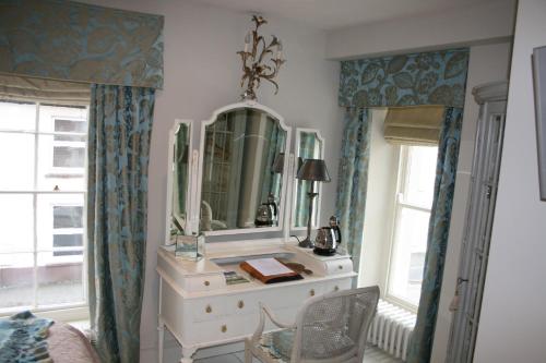 a dressing table with a mirror and a chair in a room at The New White Lion in Llandovery