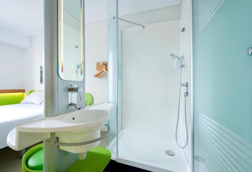 a bathroom with a sink and a shower at Ibis Budget Jakarta Daan Mogot in Jakarta