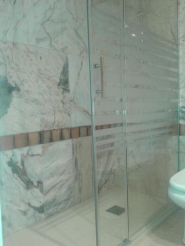 a bathroom with a glass shower with a toilet at BAJO EN COSTA GADIR in Chiclana de la Frontera