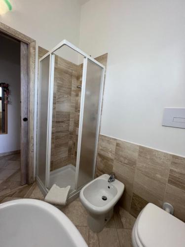 a bathroom with a shower and a toilet and a sink at Appartamento La Conchiglia a pochi passi dal centro in San Teodoro