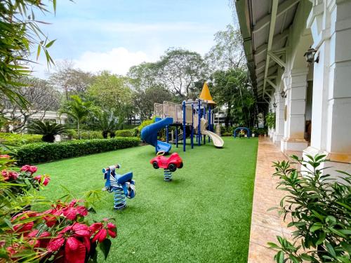 un parque infantil en un patio con césped verde en Daeha Serviced Apartment, en Hanói