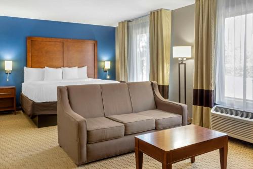 a hotel room with a bed and a couch at Comfort Inn Garner Clayton I-40 in Garner