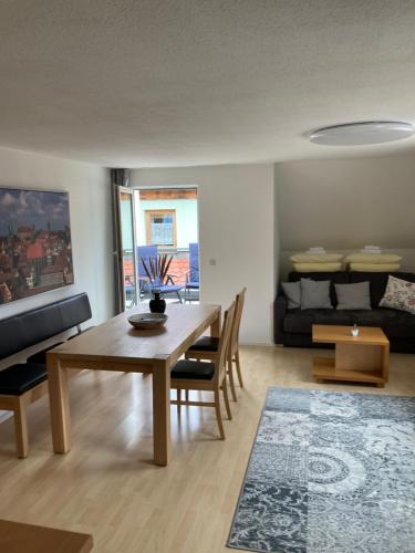 uma sala de estar com uma mesa e cadeiras e um sofá em Ferienwohnung Kellerer 2 em Waischenfeld