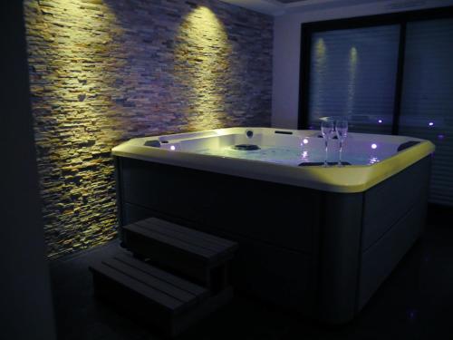 a bathroom with a tub with lights in it at Gîte Il était une fois SPA privatif in Bourgbarré