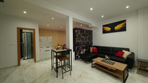 Diamond Apartment Piran FREE PARKING في بيران: غرفة معيشة مع أريكة سوداء وطاولة