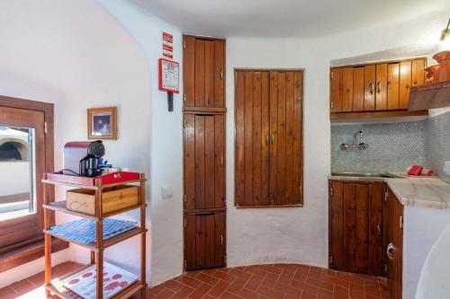 een keuken met houten kasten en een aanrecht bij Bem Parece by Umbral in Albufeira