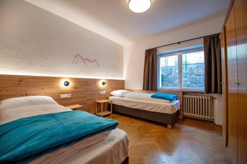 a hotel room with two beds and a window at Apartment Murata in Ortisei