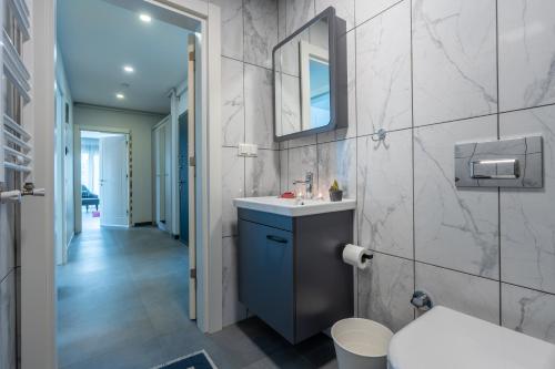 ein Bad mit einem Waschbecken und einem Spiegel in der Unterkunft Rose Residence - Trendy Apartments Near The Beach in Antalya
