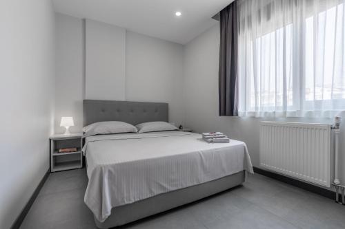 ein Schlafzimmer mit einem großen Bett und einem großen Fenster in der Unterkunft Rose Residence - Trendy Apartments Near The Beach in Antalya