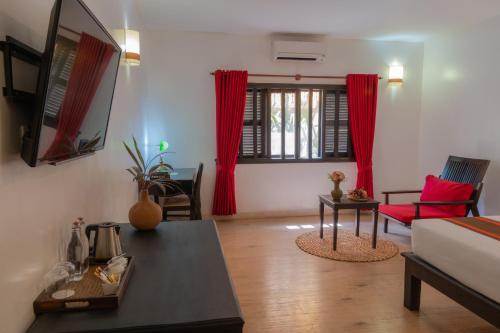 a living room with a bed and a table at Pandora Suite D'Angkor in Siem Reap