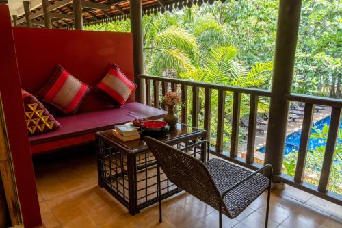 a porch with a couch and a table and chairs at Pandora Suite D'Angkor in Siem Reap