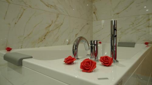 un lavabo con dos rosas rojas. en Diamond Apartment Piran FREE PARKING en Piran