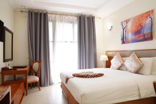 a bedroom with a bed and a desk and a window at Royal Palace Hotel in Juba