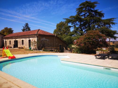 a large swimming pool in front of a house at Les Trois Jolies 