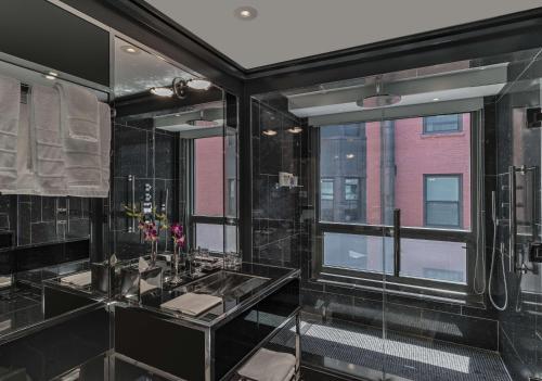 a bathroom with two sinks and a large window at The Chatwal in New York