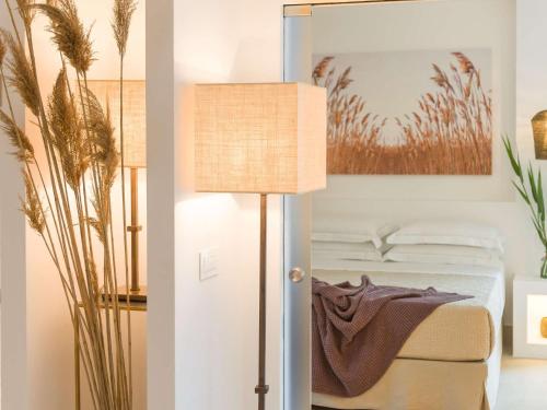een slaapkamer met een bed en een lamp bij Hotel Baia Delle Zagare in Mattinata