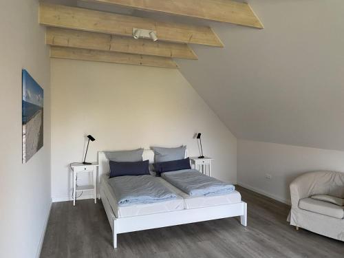 a bedroom with a white bed with blue pillows at Fischerhus in Fehmarn