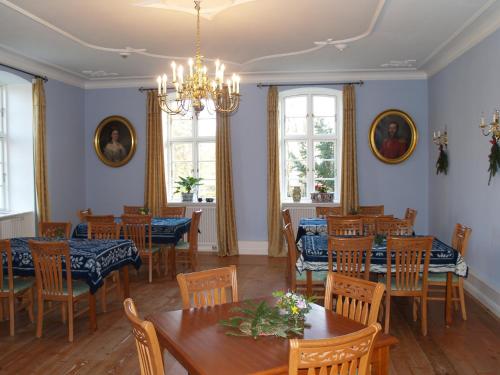 a dining room with tables and chairs and windows at Landhaus Schloss Kölzow in Kölzow