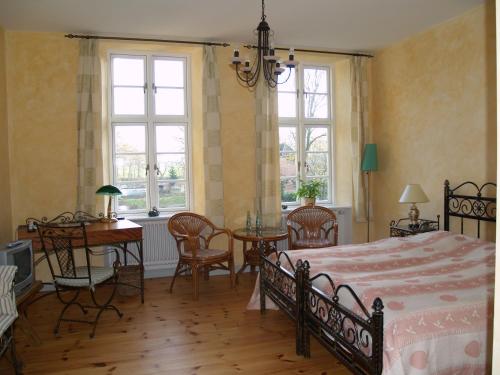 a bedroom with a bed and a table and chairs at Landhaus Schloss Kölzow in Kölzow