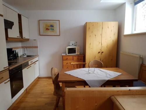 cocina con mesa de madera y cocina con microondas en Helles und großzügiges Souterrain Appartement, en Altenmarkt im Pongau