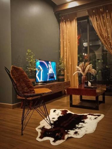 uma sala de estar com uma cadeira e uma televisão em Sky Oasis 2 Room 2wc Homestay Ecopark em Hanói