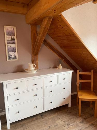 a bedroom with a white dresser and a chair at Sonniges Ferienapartment am Alten Binauer Schloss in Binau