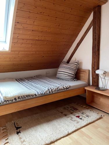 Cama en habitación con techo de madera en Sonniges Ferienapartment am Alten Binauer Schloss, 