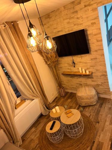 - un salon avec deux tables et une télévision à écran plat dans l'établissement Appartement Centre-ville, à Crépy-en-Valois