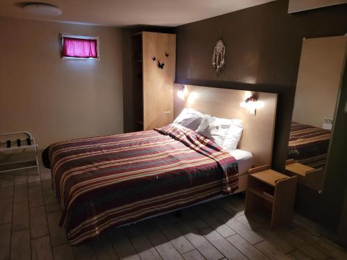 a bedroom with a large bed and a window at Le Brissoneau Rendeux in Rendeux