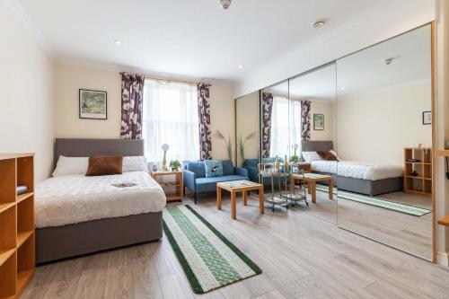 a bedroom with a bed and a living room at Elegant Art Deco whole apartment 2mins to Hyde Park, 8mins to Bayswater, Nottinghill, Paddington in London