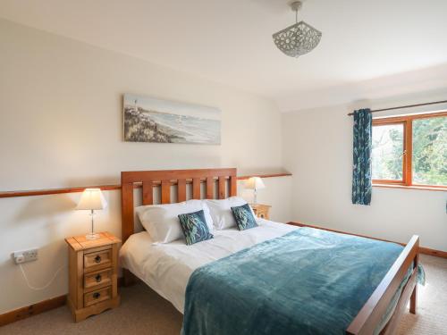 a bedroom with a large bed and a window at Long House in Beaumaris