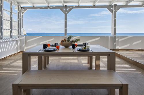 a table in a room with a view of the ocean at Soultouch Beachfront Villa in Perissa