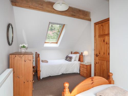 a bedroom with two beds and a window at Long Cottage in Beaumaris