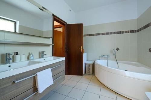 een badkamer met een groot bad en 2 wastafels bij House Fran in Barban