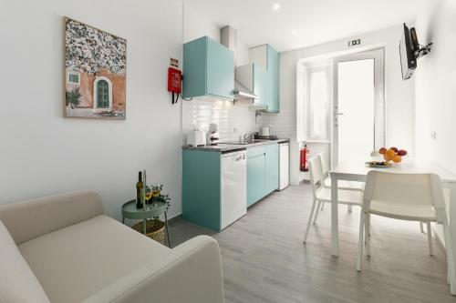a kitchen with blue cabinets and a table and chairs at Refúgio da Nazaré in Nazaré