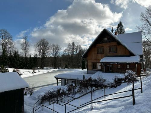a wooden house in the snow with a fence at Chalet Krakonoš by Interhome in Mladé Buky